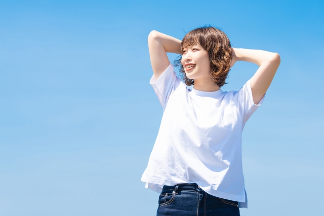 青空の下で笑顔な女性